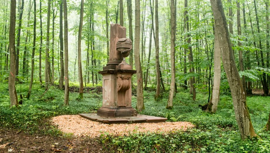 Ein historischer Obelisk mitten im Wald.